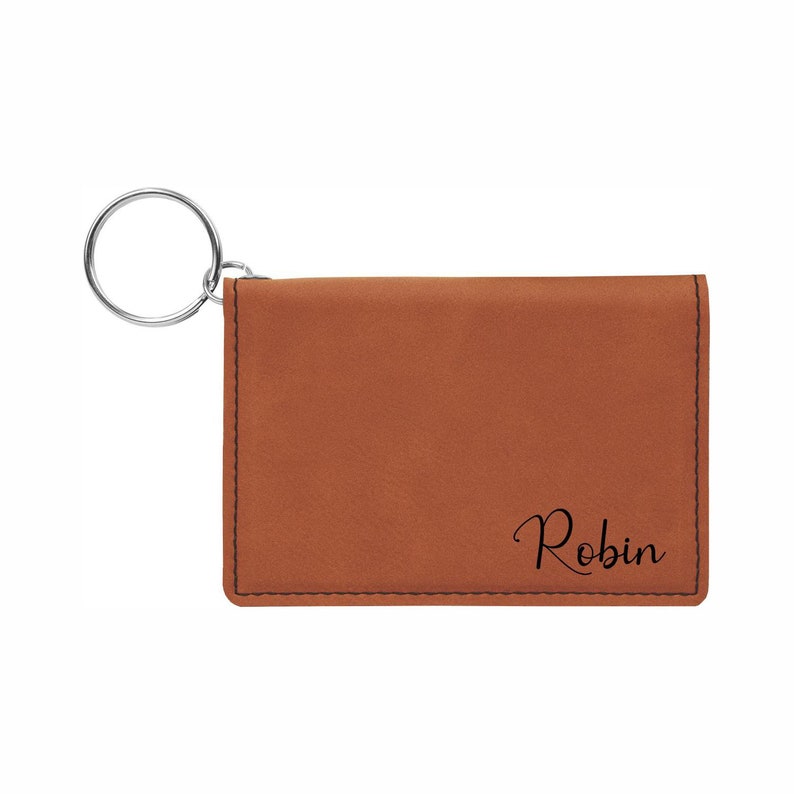 May include: A brown leather key chain with a silver ring and the name "Robin" engraved on it.