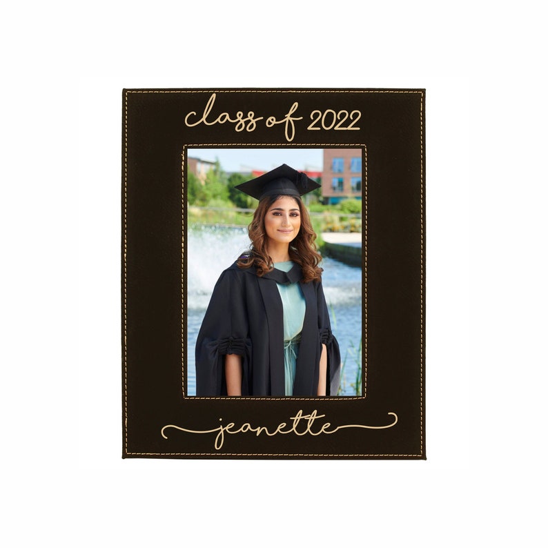 Black Leatherette Picture frame with gold engraving available in 8x10, 5x7, 4x6. We can custom engrave top and bottom. Picture as shown has Shoreline font with Class of 2022 on the top and a name on the bottom.