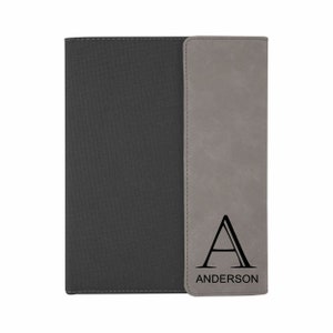 May include: A gray and black notebook with a personalized initial "A" and the name "ANDERSON" on the front.