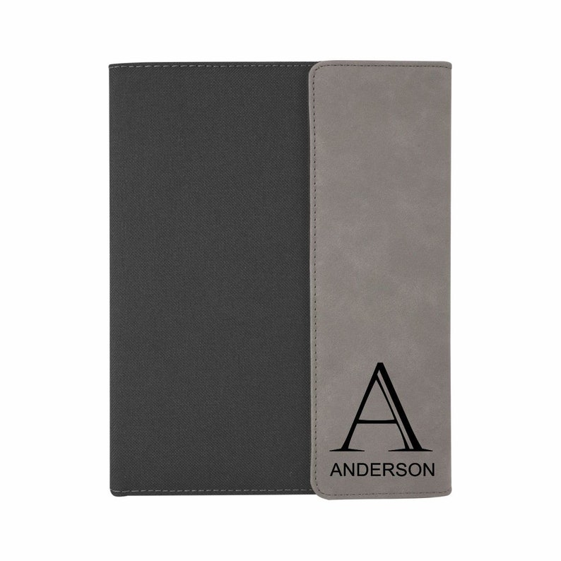 May include: A gray and black notebook with a personalized initial "A" and the name "ANDERSON" on the front.