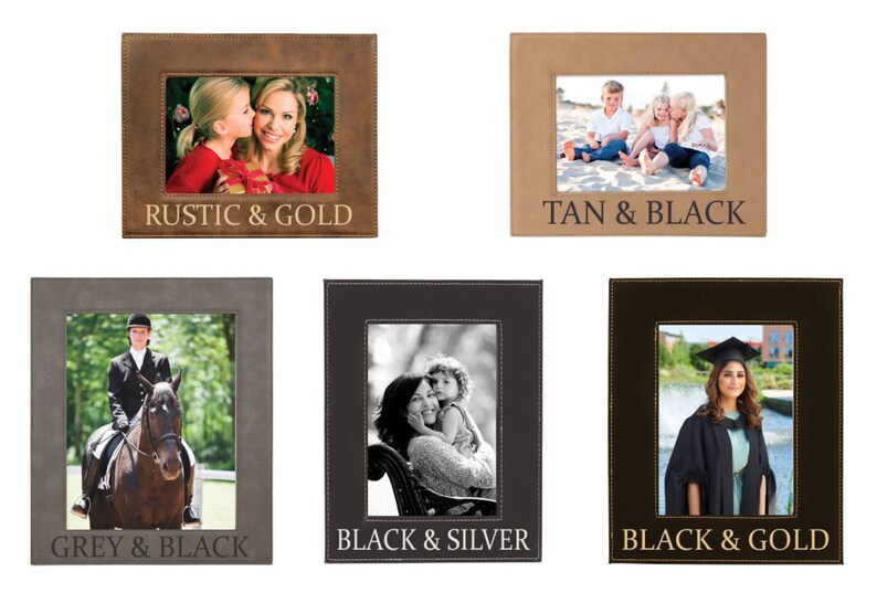 May include: Five different photo frames in various colour combinations. The frames are made of leather and have a stitched border. The frames are labelled with the colour combinations: Rustic & Gold, Tan & Black, Grey & Black, Black & Silver, and Black & Gold.