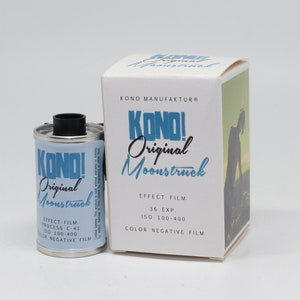 Op de afbeelding: Een rol kleurnegatief film met 36 belichtingen in een zilveren blik met een zwart deksel. Het blik heeft een blauw en wit etiket met de tekst "KONO! Original Moonstruck" en "EFFECT FILM PROCESS C-41 ISO 100-400 COLOR NEGATIVE FILM". De film is verpakt in een witte doos met dezelfde tekst en een foto van een persoon die in een veld staat.