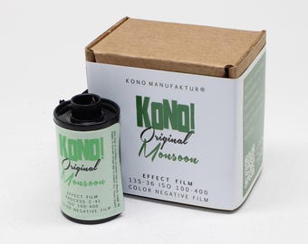 May include: A roll of Kono! Original Monsoon 35mm colour negative effect film positioned next to its matching cardboard box. The packaging and film label feature green text reading Kono! Original Monsoon, 135-36, ISO 100-400, and Process C-41.
