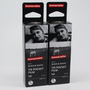 Może przedstawiać: Dwa opakowania czarno-białego filmu kieszonkowego 110, każde z 24 ekspozycjami. Film jest produkowany przez Lomography i jest oznaczony "ORCA BLACK & WHITE 110 POCKET FILM 100".
