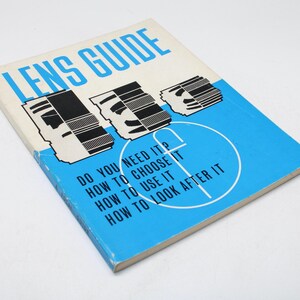 Puede incluir: Un libro vintage "LENS GUIDE" con una cubierta azul y blanca. La cubierta presenta ilustraciones de lentes de cámara y el texto "DO YOU NEED IT? HOW TO CHOOSE IT? HOW TO USE IT? HOW TO LOOK AFTER IT?"