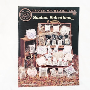 May include: A cross stitch pattern book titled "Sachet Selections" by Cross My Heart, Inc. The book cover features a variety of cross stitch designs for sachets, including flowers, birds, and letters. The book is priced at $4.00.