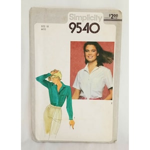 Puede incluir: Patrón de costura Simplicity número 9540 para una blusa. El patrón es para la talla 10 miss. El patrón muestra dos modelos usando la blusa. Una modelo lleva una blusa turquesa con mangas largas y la otra modelo lleva una blusa blanca con mangas cortas.