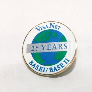 May include: A round pin with a gold border, featuring the text "Visa Net" in blue, and "25 YEARS" in silver. The center shows a blue and green globe, with the text "BASEI/BASE II" in blue.