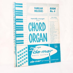 May include: A vintage music book titled Familiar Melodies Book No. 4, especially arranged for the Chord Organ. The cover features a blue and white piano key graphic, a list of song selections, and the da-mar music system logo in a blue oval.