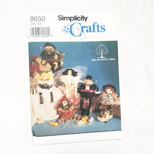 Può includere: Un modello di cucito Simplicity Crafts per realizzare sei diverse bambole. Il modello è per una sola taglia e include le istruzioni per realizzare una sposa, uno sposo, un clown, uno spaventapasseri, un pellegrino e un albero di Natale. Il numero del modello è 8650.