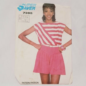 May include: A vintage sewing pattern featuring a woman wearing a pink and white striped top and pink shorts. The pattern is labeled "SUPER SAVER 7395" with sizing information. The woman is wearing a white belt and a pink bracelet.