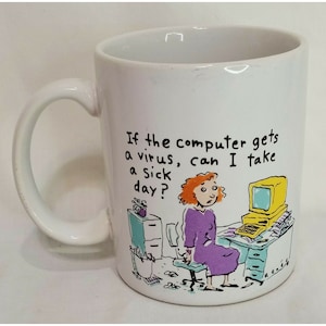 May include: White ceramic coffee mug with a cartoon illustration of a woman sitting at a desk with a computer. The text on the mug reads "If the computer gets a virus, can I take a sick day?"