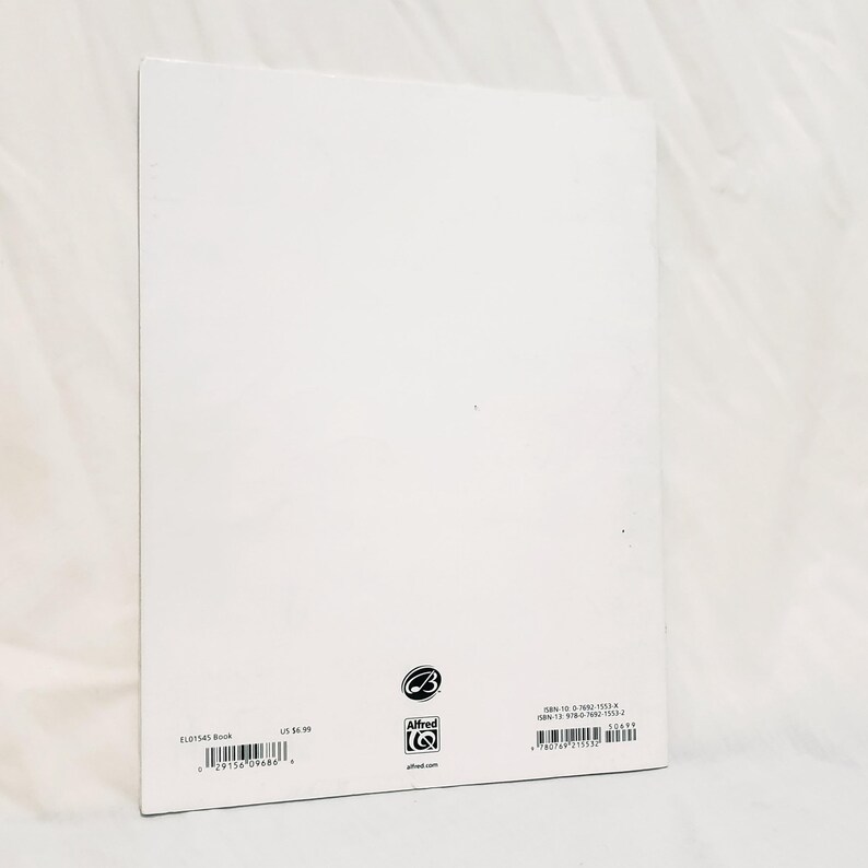 May include: The back cover of a white music book featuring the Alfred Music logo, a barcode, and ISBN numbers. The text includes EL01545 Book, US $6.99, ISBN-10: 0-7692-1553-X, ISBN-13: 978-0-7692-1553-2, and the website alfred.com at the bottom.
