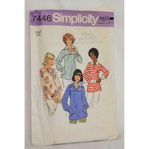 May include: A vintage Simplicity sewing pattern for a blouse, pattern number 7446. The pattern shows four different styles of blouses, including a floral print, a striped print, a solid blue, and a red and white striped blouse. The pattern is for sizes 8-10.