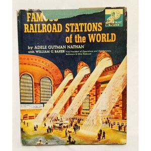 Peut inclure: Une couverture de livre vintage avec une illustration colorée de l'intérieur d'une grande gare. Le titre est "Famous Railroad Stations of the World" par Adele Gutman Nathan avec William C. Baker, Vice-président des opérations et de la maintenance, Baltimore & Ohio Railroad.