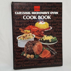 Puede incluir: Una portada de libro de cocina con fondo rojo y el texto "CAROUSEL™ MICROWAVE OVEN COOK BOOK" en blanco. La portada presenta una variedad de alimentos, incluyendo un asado, langosta y una cazuela.