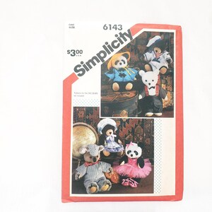 May include: Simplicity sewing pattern number 6143 for making five different stuffed animal toys. The pattern includes a panda bear wearing a yellow hat and blue jacket, a panda bear wearing a pink tutu, a bear wearing a sailor outfit, a bear wearing a dress and a bear wearing overalls. The pattern is for one size and costs $3.00.