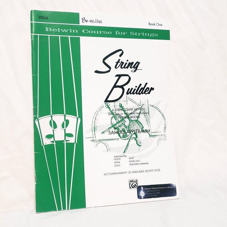 May include: A white and green music instruction book titled String Builder Book One for viola by Samuel Applebaum. The cover features a green vertical stripe with a bridge illustration, a central graphic of string instruments, and text.