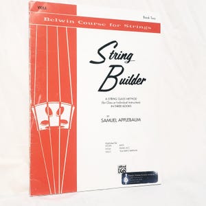 May include: A music instruction book titled String Builder Book Two for viola by Samuel Applebaum. The cover is white with a red vertical panel on the left featuring a graphic of strings and a bridge. It includes the Belwin Course for Strings text.