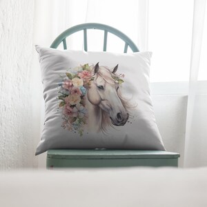May include: White horse head with a floral crown of pink, yellow, and blue flowers. The horse is facing to the right and has a white background.