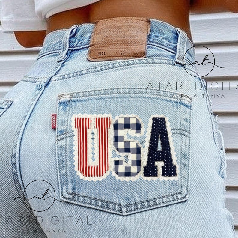 May include: Light blue denim jeans with a back pocket featuring a patriotic "USA" patch. The patch includes red and white stripes, a blue and white gingham pattern, and a navy blue polka dot design.