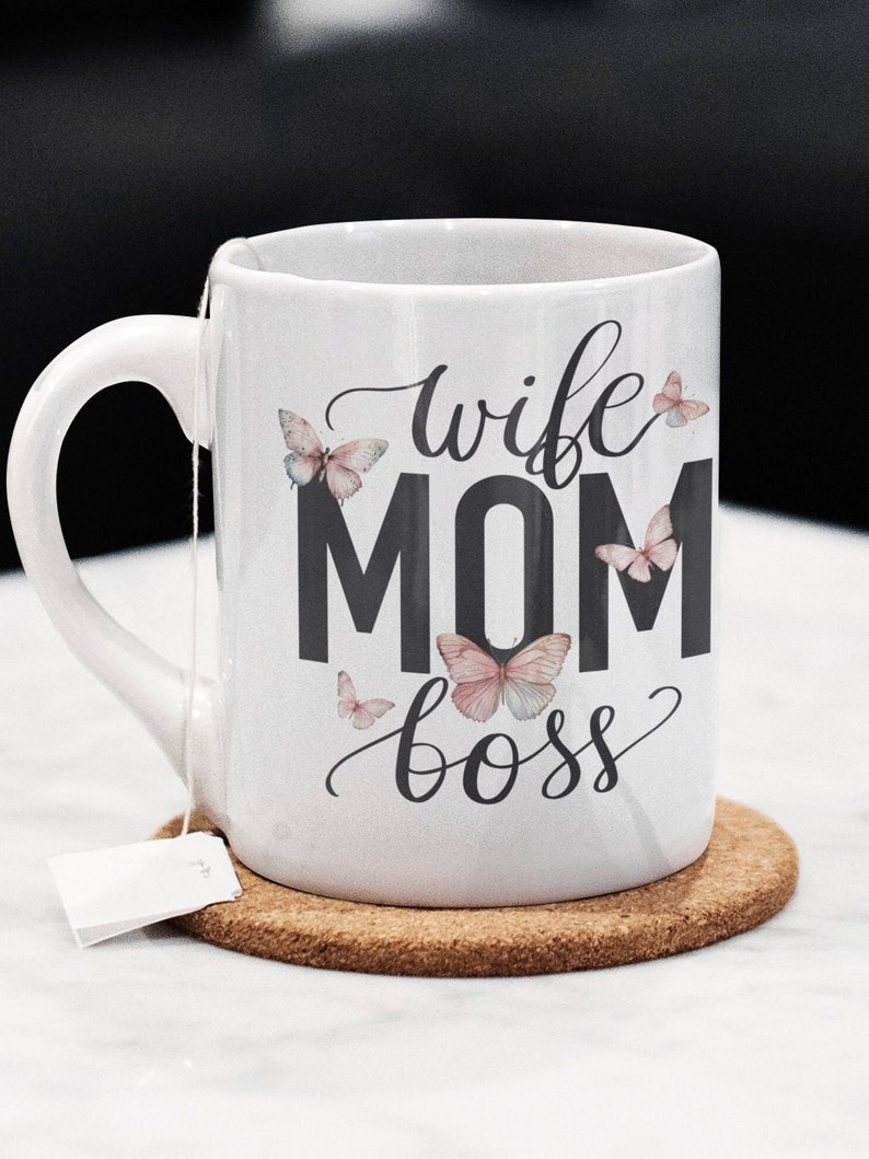 May include: White ceramic mug with a black design that says "wife mom boss" with butterflies around the text.