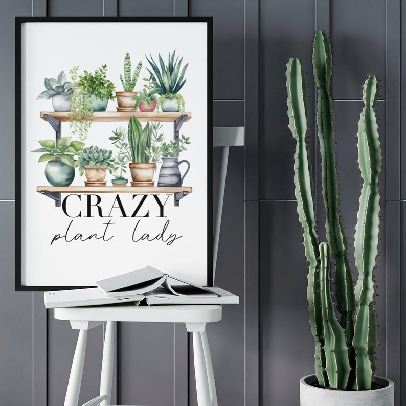 May include: A white framed print with a watercolor illustration of a shelf with potted plants. The text "CRAZY plant lady" is below the shelf.