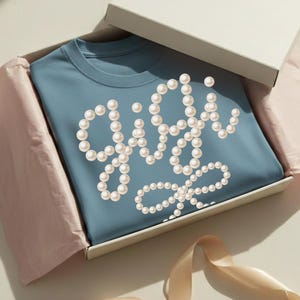 May include: A rustic wooden sign with the text "Welcome" in a handwritten style. The sign is painted white with a distressed finish, and features a decorative floral element. The sign measures approximately 12 inches wide.