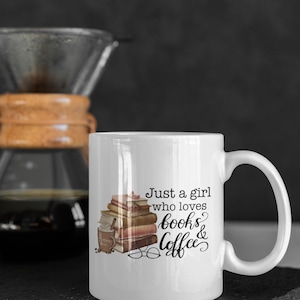 May include: White ceramic mug with a black and brown illustration of a stack of books, a cup of coffee, and a pair of glasses. The text "Just a girl who loves books & coffee" is printed on the mug.