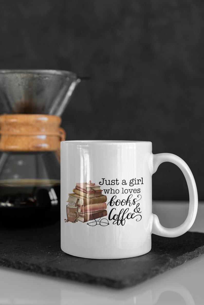 May include: White ceramic mug with a black and brown illustration of a stack of books, a cup of coffee, and a pair of glasses. The text "Just a girl who loves books & coffee" is printed on the mug.