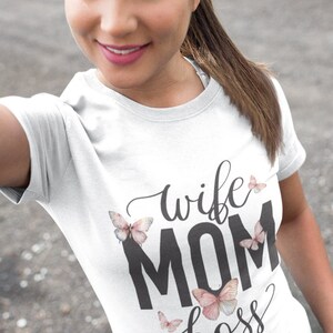 May include: White t-shirt with the text "wife mom boss" in black lettering and pink butterfly graphics.