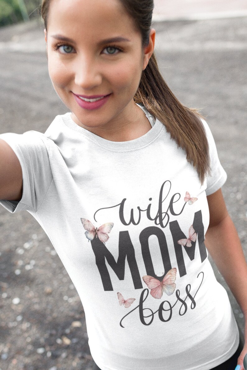 May include: White t-shirt with the text "wife mom boss" in black lettering and pink butterfly graphics.