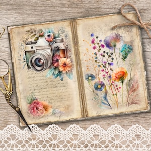 May include: An open vintage journal with a watercolour illustration of a camera and flowers on the left page and a watercolour illustration of wildflowers on the right page. The journal is on a wooden surface with a lace trim at the bottom.