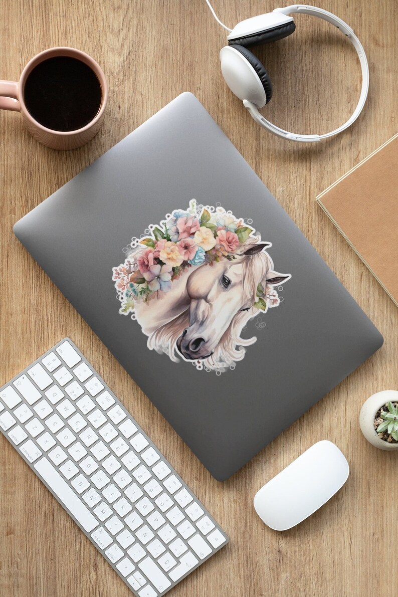 May include: A white horse with a floral crown made of pink, yellow, and blue flowers. The horse's head is turned to the side, and its eyes are closed. The background is a soft, watercolor-like wash of color.