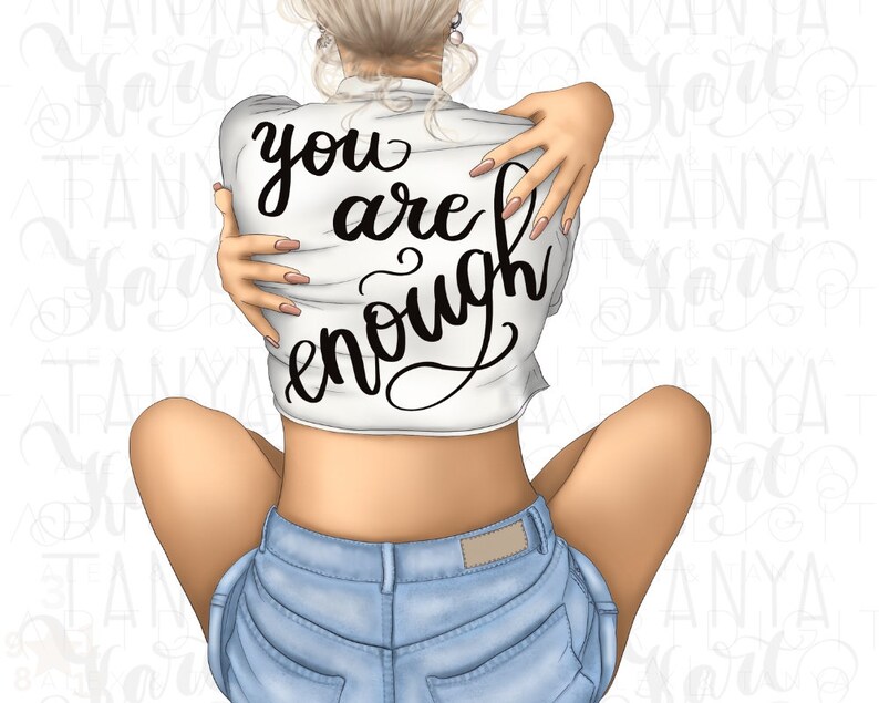 K&ouml;nnte beinhalten: Eine Frau tr&auml;gt ein wei&szlig;es Shirt mit dem Text "you are enough" in Schwarz. Sie tr&auml;gt Jeans-Shorts und hat ihre Arme um sich selbst geschlungen.