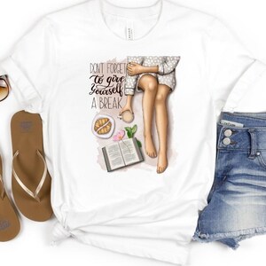 May include: White t-shirt with a graphic of a woman sitting with a book, coffee, and pastries. The text on the shirt reads "Don't forget to give yourself a break."
