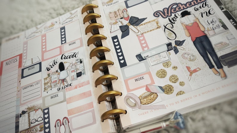 May include: A pink and white planner with gold rings. The planner has stickers with the text "Write Create Inspire" and "Plan Your Weekend with Me".