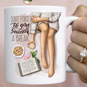 May include: White ceramic mug with a colorful illustration of a person sitting with a book, a cup of coffee, and a croissant. The text "Don't forget to give yourself a break" is printed on the mug.