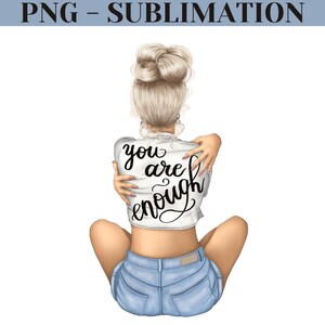 K&ouml;nnte beinhalten: Eine Frau mit blonden Haaren sitzt mit gekreuzten Beinen und hat die Arme um sich selbst geschlungen. Sie tr&auml;gt ein wei&szlig;es Shirt mit dem Text "you are enough" darauf. Au&szlig;erdem tr&auml;gt sie eine blaue Jeans-Shorts.