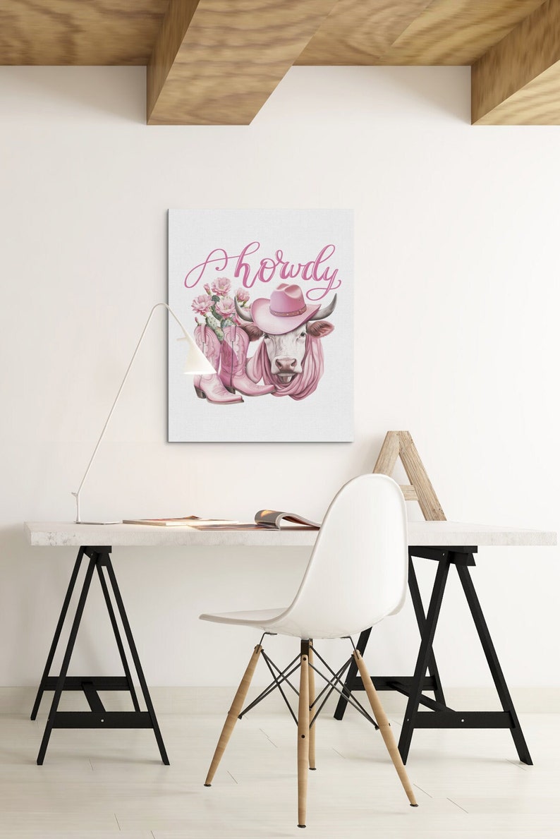 May include: A pink cow wearing a pink cowboy hat and pink boots with a floral design. The text "Howdy" is written in pink above the cow.