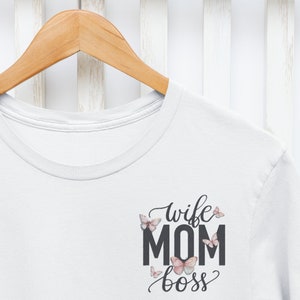 May include: White t-shirt with a black graphic that says "wife mom boss" with butterflies around the text.