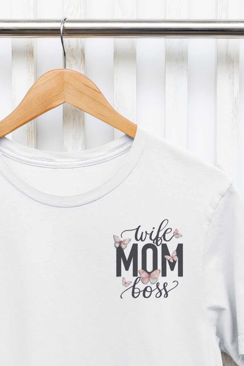 May include: White t-shirt with a black graphic that says "wife mom boss" with butterflies around the text.
