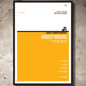 Puede incluir: Un póster amarillo con un marco negro que presenta una ilustración en blanco y negro de un ciclista. El póster se titula "Contre La Montre Individuel Bradley Wiggins" e incluye el texto "99 édition Le Tour de France 2012 Tour Classique".