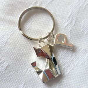 May include: Silver key chain with a silver origami cat charm and a silver letter 'P' charm.