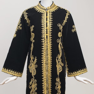 May include: A floor-length black kaftan featuring intricate gold embroidery along the center front, neckline, and sleeve cuffs. The garment has long, wide sleeves, a mandarin collar, and a vertical pattern of gold thread detailing.