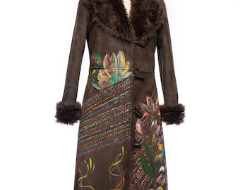 May include: A long brown coat with a faux fur collar and cuffs. The coat features hand-painted floral designs in shades of orange, green, and brown. The coat has a suede-like texture and a unique, artistic style.