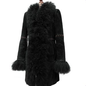 May include: A black coat with a fur collar and cuffs. The coat has a long, tailored silhouette with decorative stitching on the sleeves. The fur trim adds a touch of luxury to this outerwear piece.