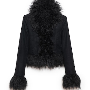 May include: A white ceramic mug with a black handle and the text "But First, Coffee" in a black, bold font. The mug is on a white surface. The mug is approximately 10 cm tall.