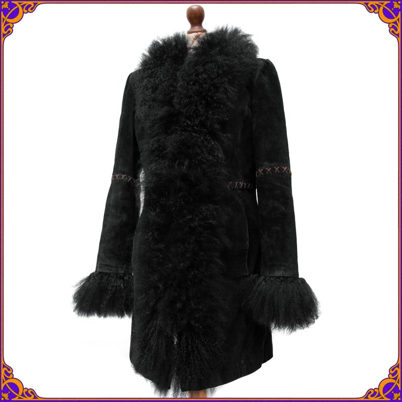 May include: A black coat with a fur collar and cuffs. The coat has a long, tailored silhouette with decorative stitching on the sleeves. The fur trim adds a touch of luxury to this outerwear piece.