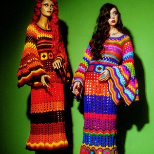 May include: Two mannequins wearing colorful, crochet dresses with bell sleeves and flared skirts. One dress is in shades of red, orange, and brown. The other is a rainbow of colors. The background is a solid green.